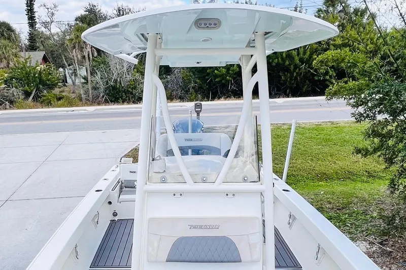 Slide: The Image of 2015 Pathfinder 2600 HPS boat with T-top, parked near a road and greenery. - 15