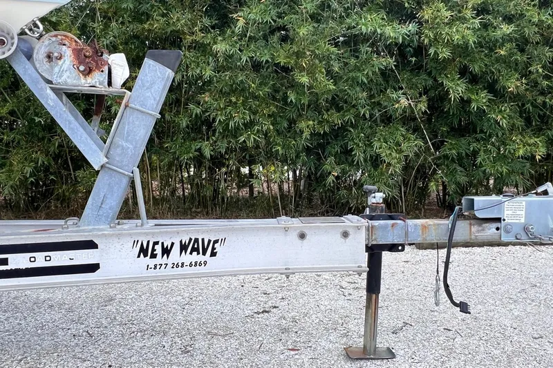Slide: The Image of Trailer for 2015 Pathfinder 2600 HPS boat, labeled "New Wave," parked on gravel. - 28