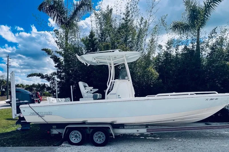 Slide: The Image of 2015 Pathfinder 2600 HPS boat on trailer, surrounded by palm trees and blue sky. - 8