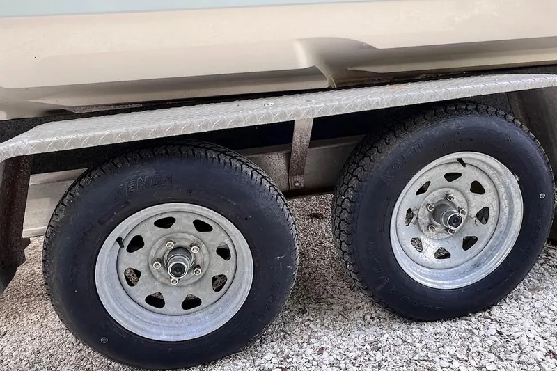 Slide: The Image of Trailer wheels of a 2015 Pathfinder 2600 HPS boat on gravel surface. - 27