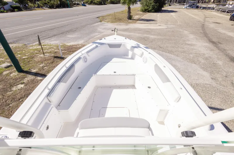 Slide: The Image of 2016 Everglades 243 Center Console boat with seating and steering, parked near a road. - 17
