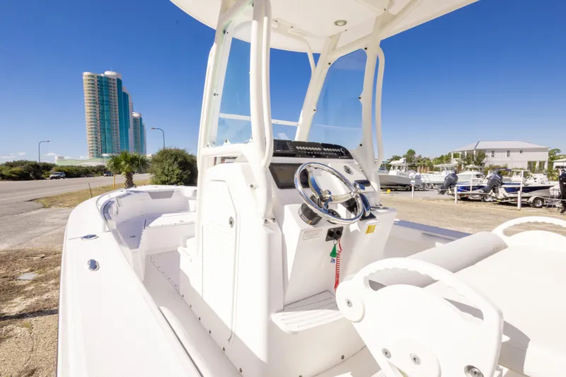 Slide: The Image of 2016 Everglades 243 Center Console boat parked near marina, clear blue sky. - 18