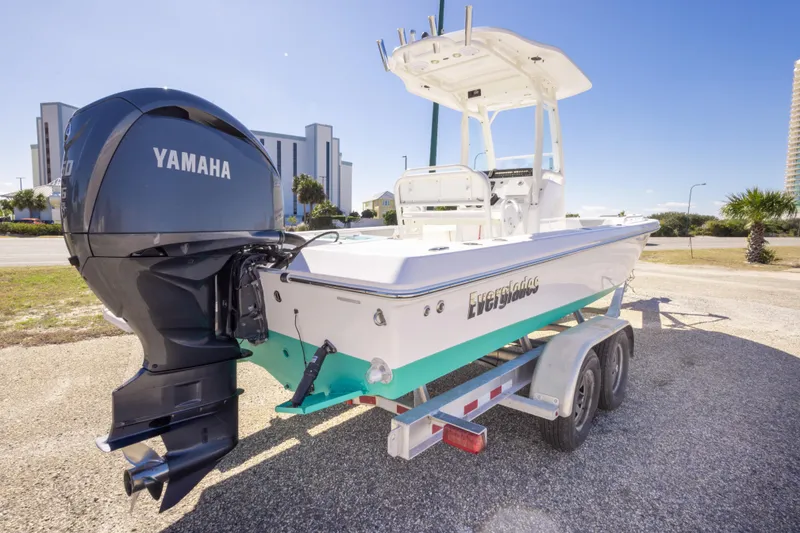Slide: The Image of 2016 Everglades 243 Center Console boat on trailer, urban backdrop, clear sky. - 2