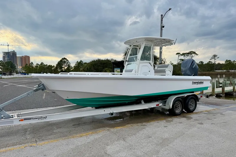 Slide: The Image of 2016 Everglades 243 Center Console boat on trailer, parked near marina under cloudy sky. - 32