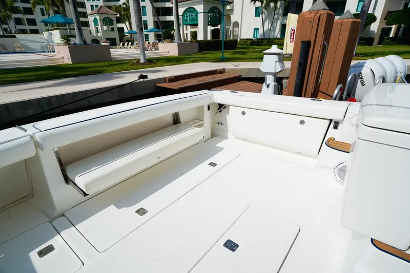 Slide: The Image of 2005 Tiara Yachts 3800 Open boat deck with seating and storage, docked near a resort. - 15