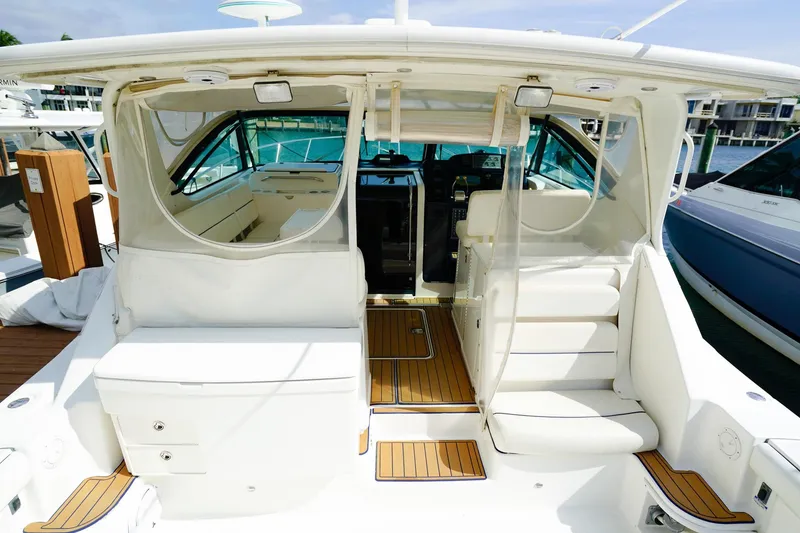 Slide: The Image of 2005 Tiara Yachts 3800 Open, luxurious interior view with white seating and wood accents. - 17