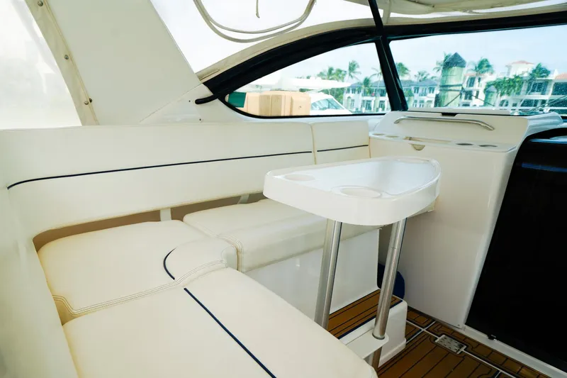 Slide: The Image of Interior of 2005 Tiara Yachts 3800 Open, featuring white seating and a compact table. - 19