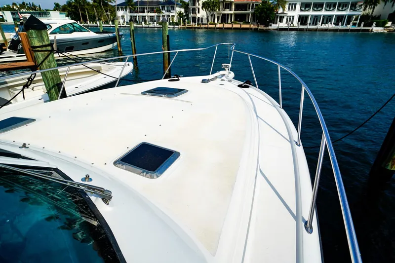 Slide: The Image of 2005 Tiara Yachts 3800 Open docked, showcasing sleek deck and waterfront view. - 38