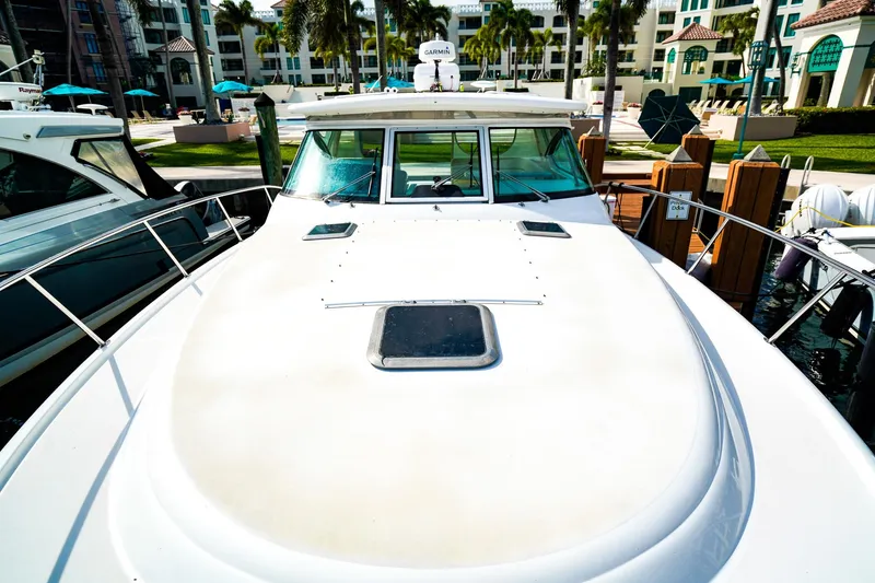 Slide: The Image of 2005 Tiara Yachts 3800 Open docked at a marina with palm trees. - 41