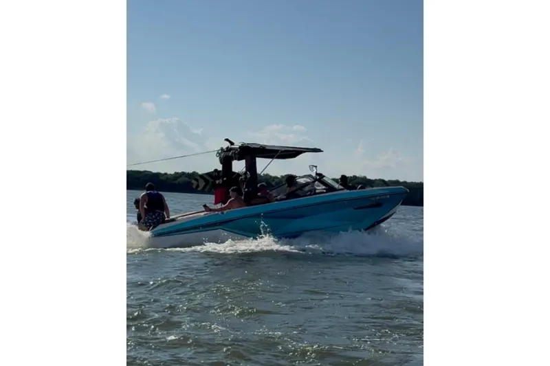 Slide: The Image of 2022 Nautique Super Air Nautique G23 boat on trailer, blue and white design. - 1