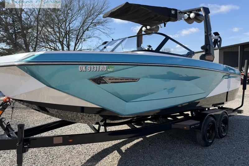 Slide: The Image of 2022 Nautique Super Air Nautique G23 boat interior with storage compartment and cup holders. - 16