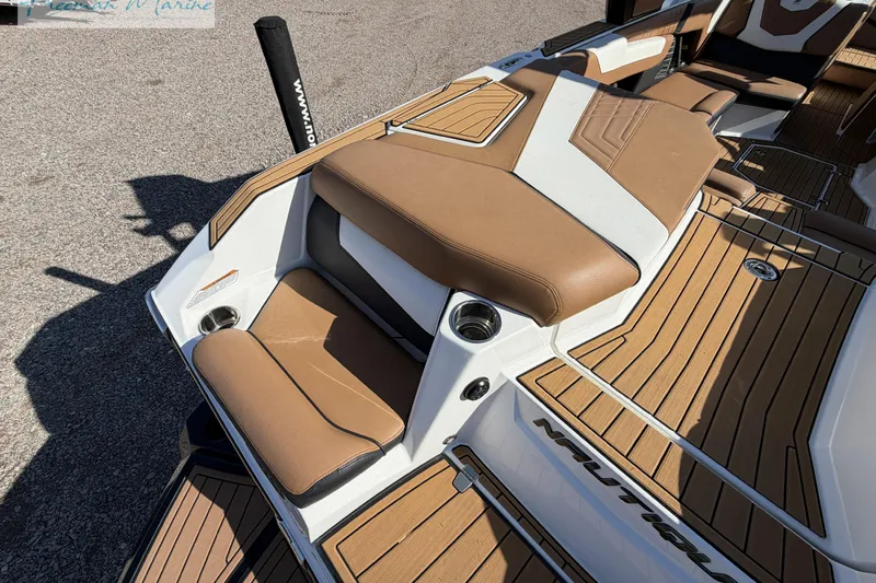 Slide: The Image of 2022 Nautique Super Air Nautique G23 boat interior with tan seating and deck. - 18
