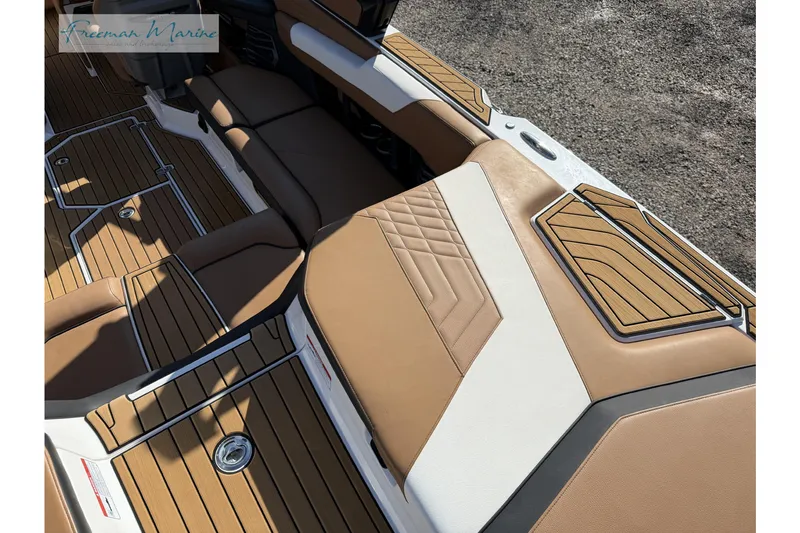 Slide: The Image of 2022 Nautique Super Air Nautique G23 interior with tan seating and teak-style flooring. - 21