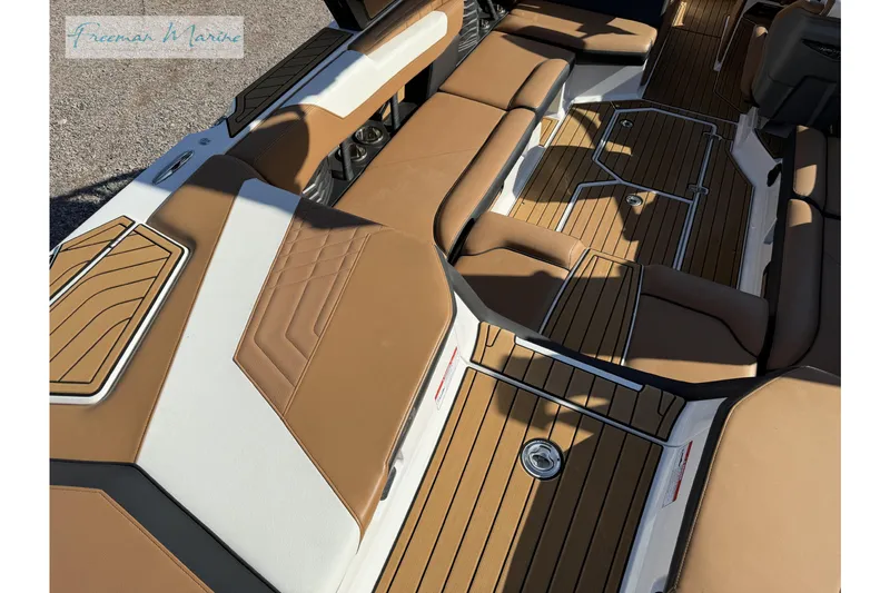 Slide: The Image of 2022 Nautique Super Air Nautique G23 boat with speakers, parked outdoors under blue sky. - 22