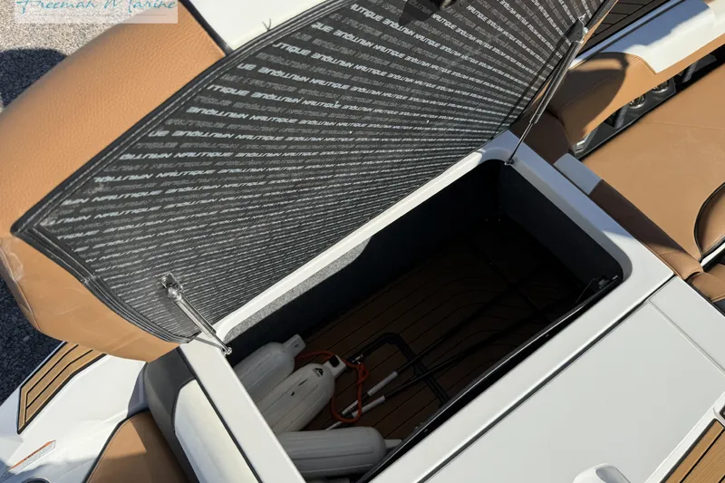 Slide: The Image of 2022 Nautique Super Air Nautique G23 storage compartment with open hatch and teak flooring. - 26