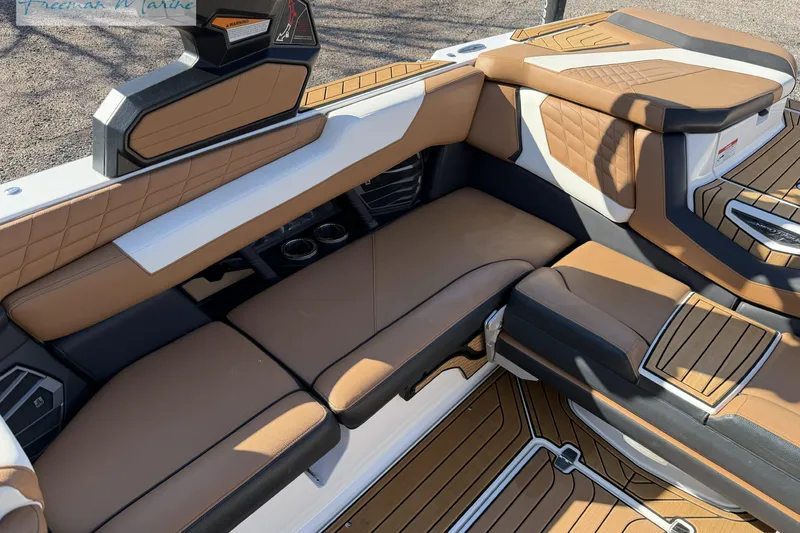 Slide: The Image of 2022 Nautique Super Air Nautique G23 interior with tan and black seating, cup holders. - 35