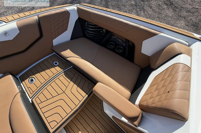 Slide: The Image of 2022 Nautique Super Air Nautique G23 interior with tan leather seating and cup holders. - 54