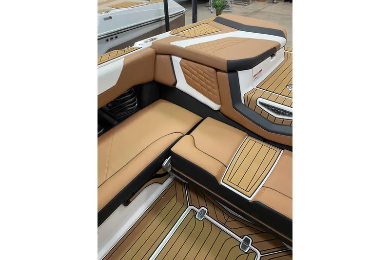 Slide: The Image of 2022 Nautique Super Air Nautique G23 boat with teak deck and seating, parked outdoors. - 6