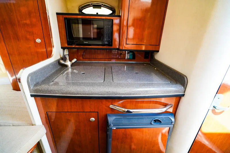 Slide: The Image of 2007 Sea Ray 280 Sundancer galley with microwave, sink, and compact fridge. - 19