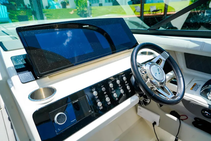 Slide: The Image of 2022 Sea Ray SLX 310 OB helm with modern controls and sleek steering wheel. - 18