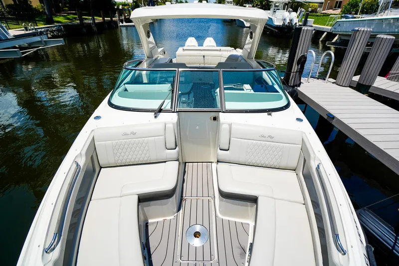 Slide: The Image of 2022 Sea Ray SLX 310 OB boat with luxurious seating and sleek design at a dock. - 26