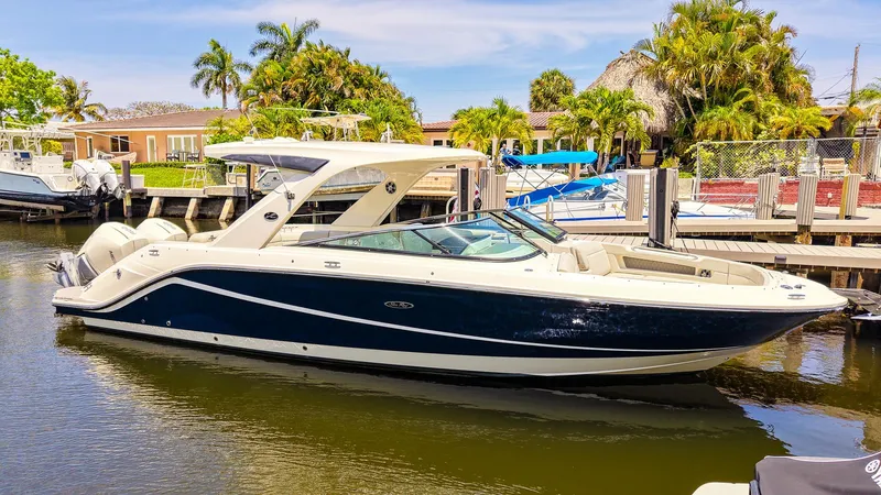 Slide: The Image of 2022 Sea Ray SLX 310 OB boat docked in a sunny marina setting. - 28