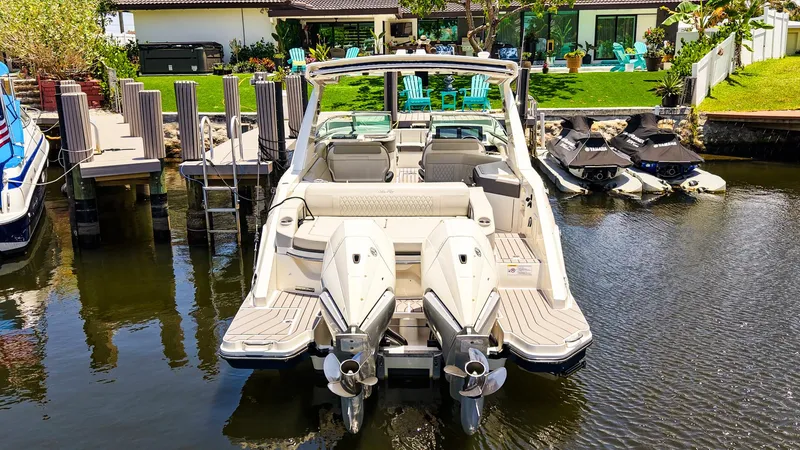 Slide: The Image of 2022 Sea Ray SLX 310 OB boat docked near waterfront property. - 5