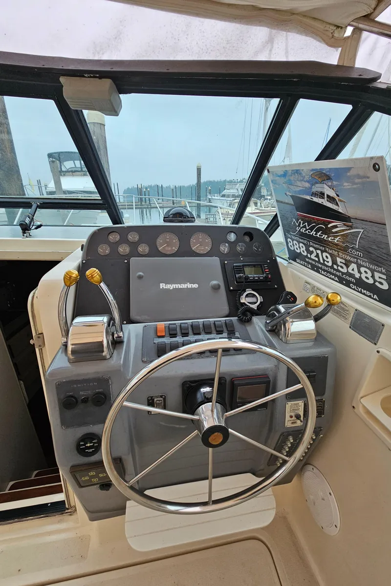 Slide: The Image of 1996 Tiara Yachts 3100 EXPRESS helm with steering wheel and navigation controls. - 11