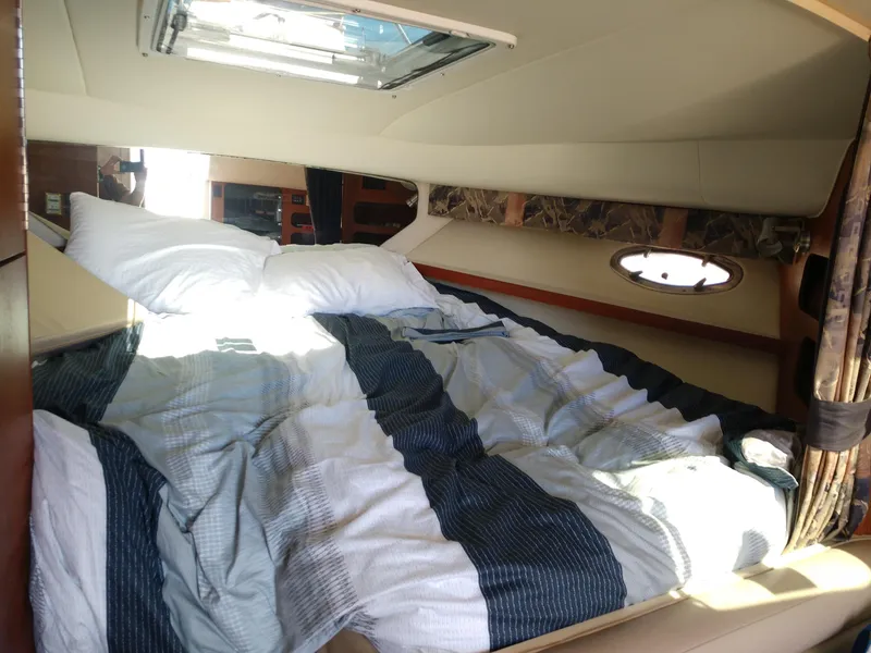 Slide: The Image of 1996 Tiara Yachts 3100 EXPRESS cabin interior with bed and porthole window. - 16