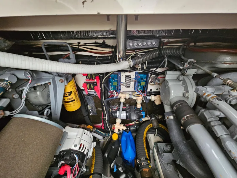 Slide: The Image of Engine compartment of a 1996 Tiara Yachts 3100 EXPRESS, showcasing mechanical components and wiring. - 27