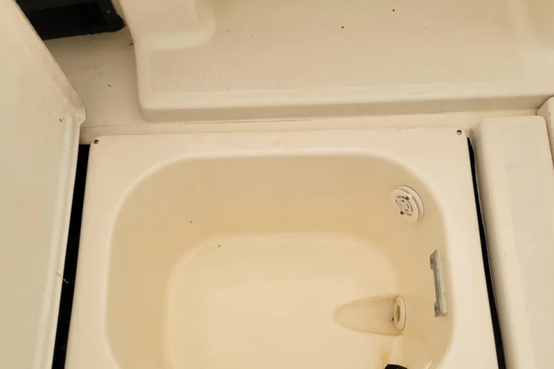 Slide: The Image of 1996 Tiara Yachts 3100 Open boat interior compartment with drain and fittings. - 34