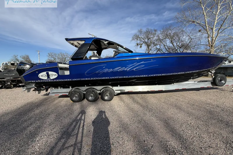 Slide: The Image of 2024 Cigarette 41' Nighthawk boat in vibrant blue on a trailer, parked outdoors. - 1