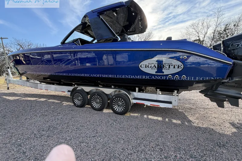 Slide: The Image of 2024 Cigarette 41' Nighthawk boat on trailer, blue exterior, parked outdoors. - 15