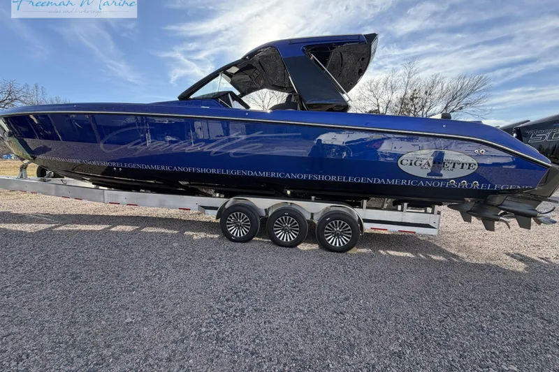 Slide: The Image of 2024 Cigarette 41' Nighthawk boat on trailer, blue exterior, parked outdoors. - 18