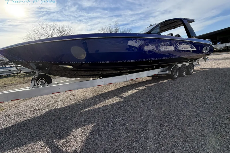 Slide: The Image of 2024 Cigarette 41' Nighthawk boat on trailer, sleek design, blue hull, outdoor setting. - 19
