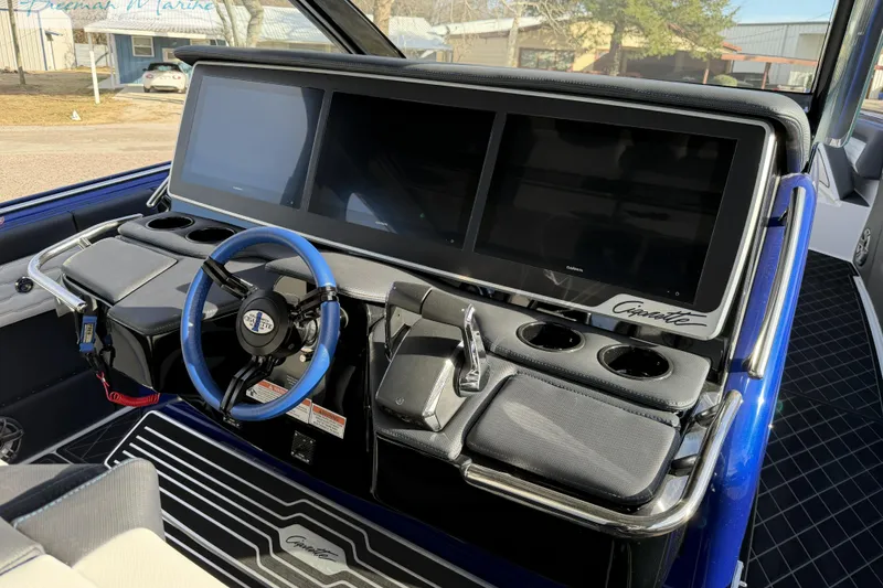 Slide: The Image of 2024 Cigarette 41' Nighthawk boat dashboard with dual screens and blue steering wheel. - 21