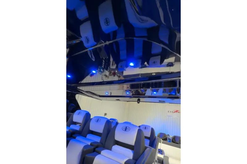 Slide: The Image of 2024 Cigarette 41' Nighthawk interior with blue ambient lighting and luxurious seating. - 26