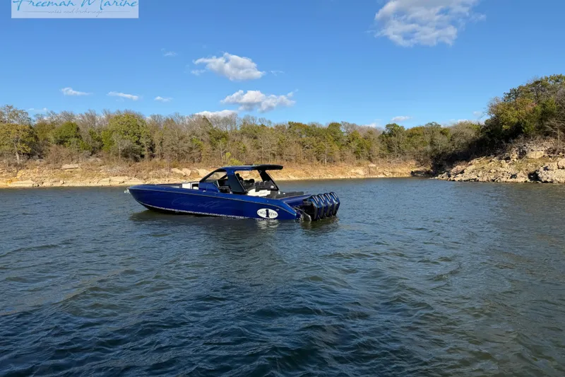 Slide: The Image of 2024 Cigarette 41' Nighthawk boat on a serene lake with wooded shoreline. - 29