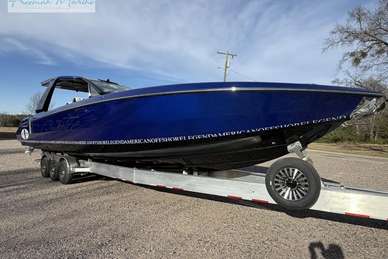 Slide: The Image of 2024 Cigarette 41' Nighthawk boat on trailer, sleek blue design, parked outdoors. - 7
