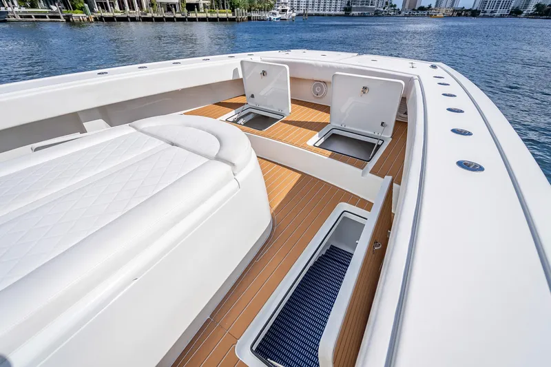Slide: The Image of 2019 Freeman 42LR boat deck with open storage compartments on calm water. - 17