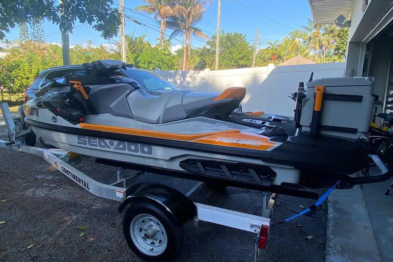 Slide: The Image of 2022 Sea-Doo FishPro Trophy 170 on trailer, parked outdoors near trees. - 2
