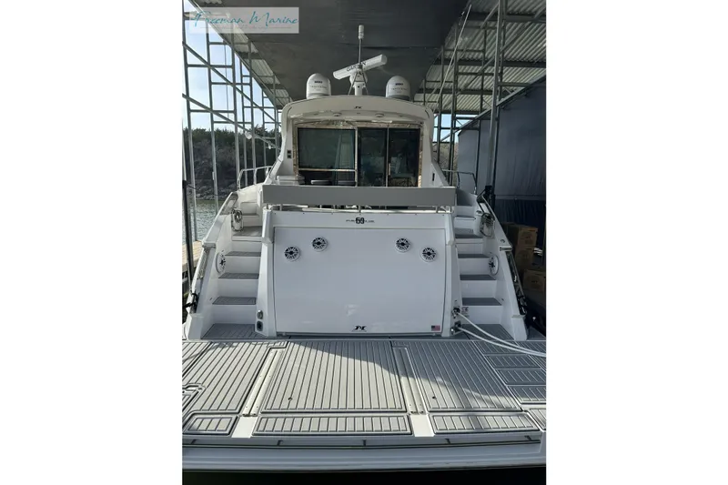 Slide: The Image of 2022 Cruisers Yachts 60 Cantius docked, rear view showing deck and stairs. - 45