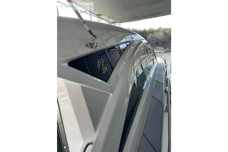 Slide: The Image of 2022 Cruisers Yachts 60 Cantius, sleek exterior design under a covered dock. - 47