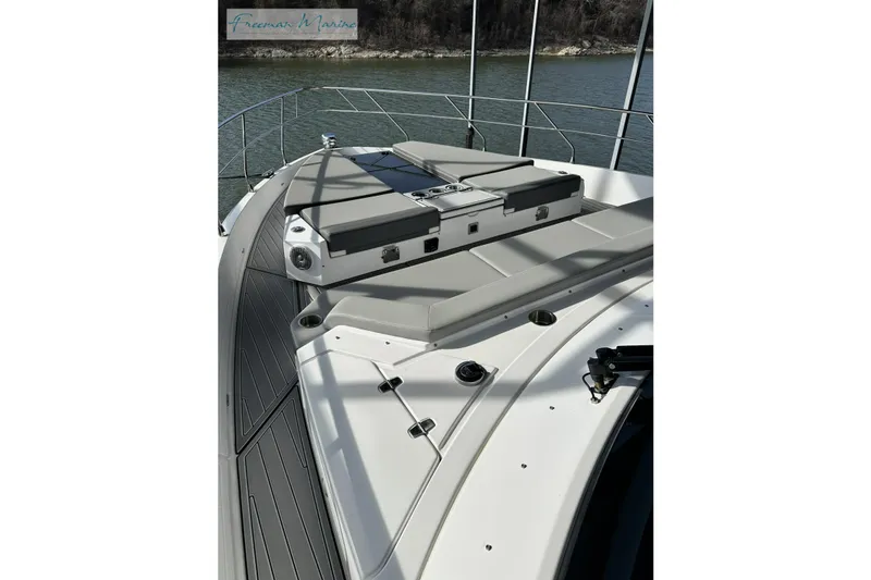 Slide: The Image of 2022 Cruisers Yachts 60 Cantius deck with sunpad, sleek design, and water view. - 53