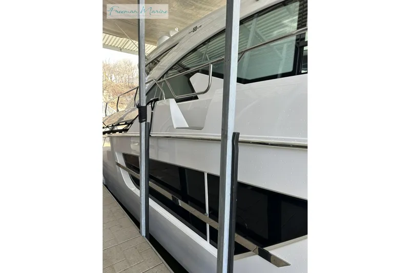 Slide: The Image of 2022 Cruisers Yachts 60 Cantius, sleek white exterior, docked under shelter. - 72