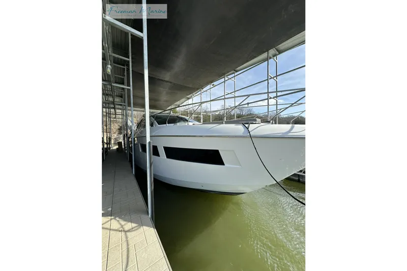 Slide: The Image of 2022 Cruisers Yachts 60 Cantius docked in a covered marina. - 73
