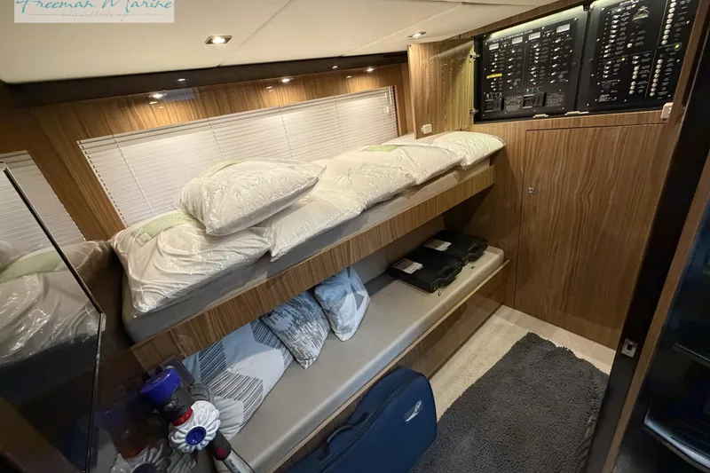 Slide: The Image of 2022 Cruisers Yachts 60 Cantius interior cabin with bunk beds and control panel. - 77