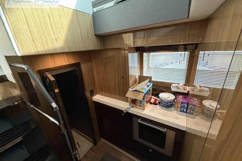 Slide: The Image of Modern kitchen interior of 2022 Cruisers Yachts 60 Cantius with wood paneling and appliances. - 78