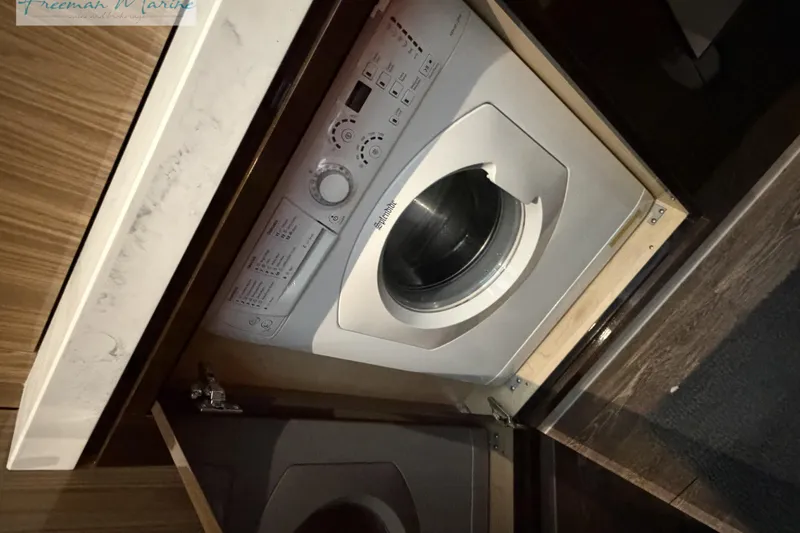 Slide: The Image of Built-in washing machine on 2022 Cruisers Yachts 60 Cantius, wooden cabinetry. - 80