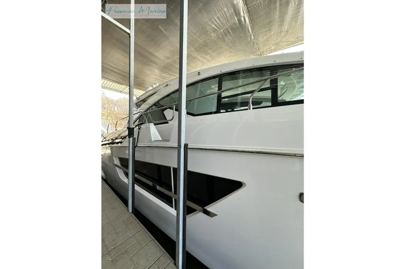 Slide: The Image of 2022 Cruisers Yachts 60 Cantius, side view under cover, showcasing sleek design. - 2